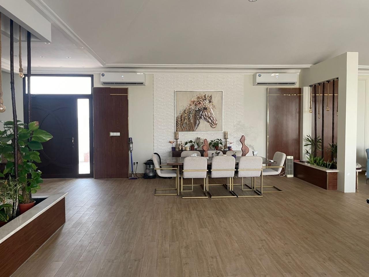 Dining room with a white table setting beneath a framed equestrian portrait.