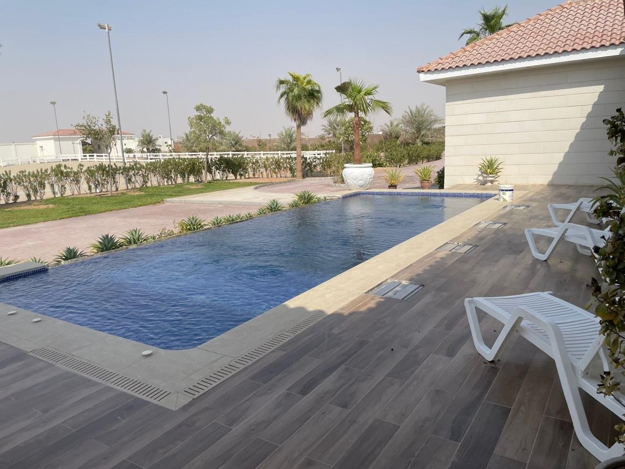 Pool deck and paved surround seen from the shaded end of the terrace.